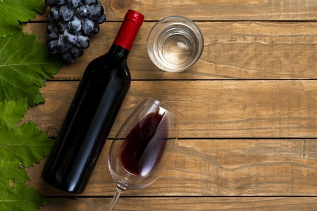 Wine bottle glass grapes on wooden background. Top view with copy space.の写真素材