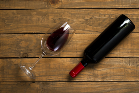 Bottle of wine and glass on wooden background. Top view with copy space.の写真素材