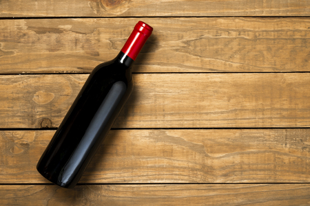 Bottle of wine on wooden background. Top view with copy space.の写真素材