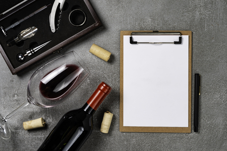Accessories for oenology. Cup with wine on concrete background and notepad. Copy Space.の写真素材