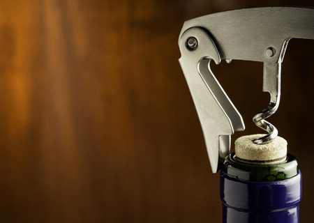 Bottle of wine with corkscrew on wooden background.の写真素材