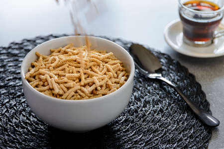 Breakfast with whole wheat cereal and corn with plum falling into the bowl - All fibrous.の写真素材