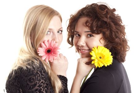 Two young beautiful girls with flowersの写真素材
