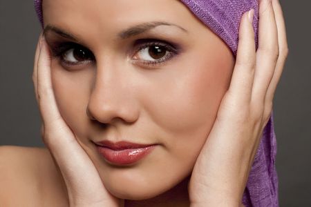 Portrait of the beautiful brunette in a violet scarfの写真素材