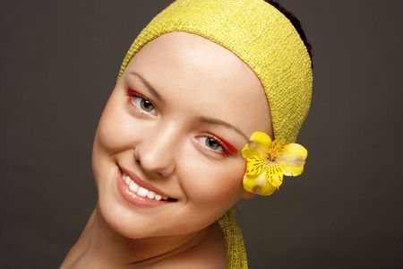 beautiful smiling girl with a yellow flowerの写真素材