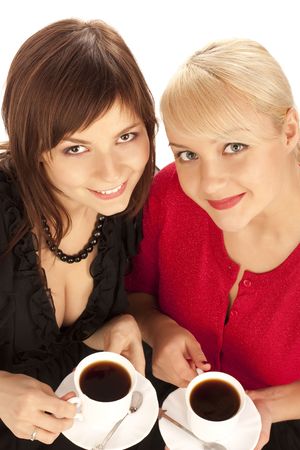 two girls drinking coffee over white backgroundの写真素材