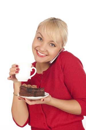 Smiling young blond woman holding a phone and cap of coffee. Isolated on a white backgroundの写真素材