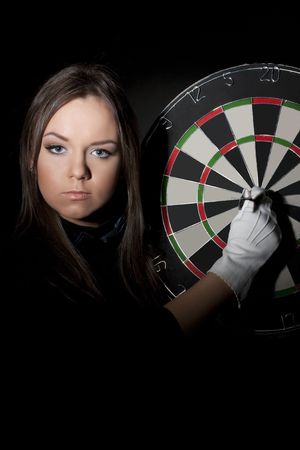 Girl holding a dart over a center of a target の写真素材