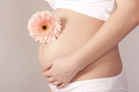Pregnant woman with pink flowerの写真素材