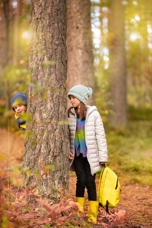 A boy and a girl are walking in the autumn forestの写真素材