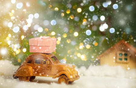 Retro car is carrying a Christmas gift. Online store and delivery conceptの写真素材