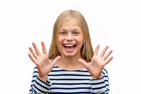 TEENAGE GIRL SMILES AND SHOWS HER OPEN HANDS WITH HER PALMS. ISOLATE ON A WHITE BACKGROUNDの写真素材