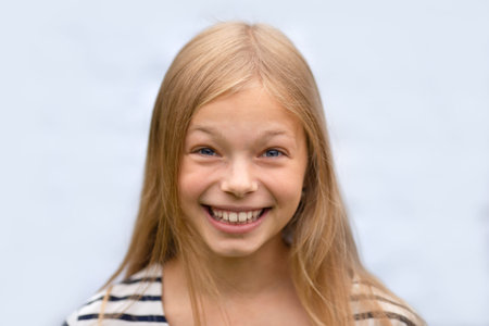 Teenage girl laughs. Isolated on a gray background