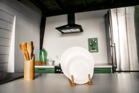 wooden kitchen utensils in a wooden glass on the background of a beautiful modern kitchen White...