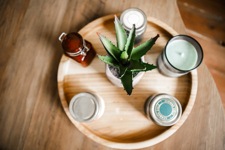 Interior items: candles, aromatic sachets, aloe flower on a wooden round stand