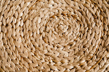 Closeup wicker rug, pattern, weaving texture wicker mat background, wooden background, table mat, handmade straw weaving Rustic style table mat round dining rugの写真素材