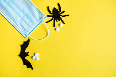 protective mask on a yellow background with the inscription Halloween. Halloween symbol 2020の写真素材