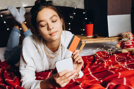 Young woman enjoying shopping online for Christmas. christmas shopping and salesの写真素材