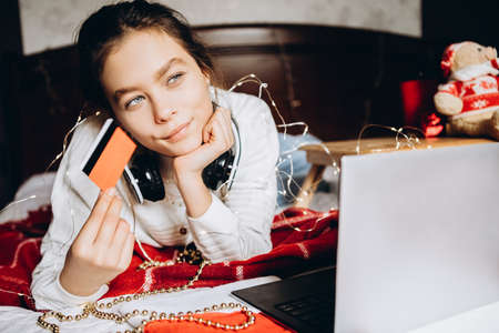 Young woman enjoying shopping online for Christmas.の写真素材