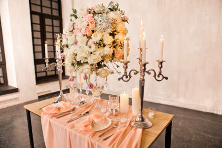 Decorating a wedding table with candles and expensive dishesの写真素材