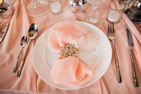 Wedding table setting with tablecloths, dishes and decorations.の写真素材