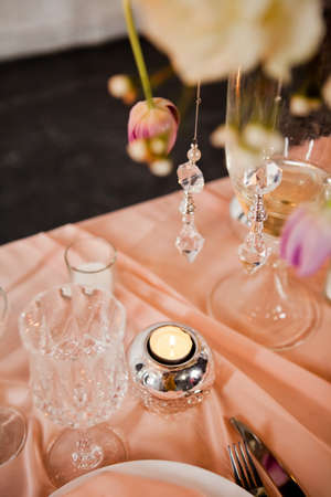 Wedding table setting with tablecloths, dishes and decorations.の写真素材