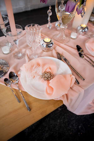 Wedding table setting with tablecloths, dishes and decorations.の写真素材