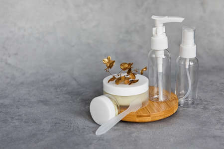 A jar of face cream on a wooden stand on a gray background. Set for skin and body care beauty products banner formatの写真素材