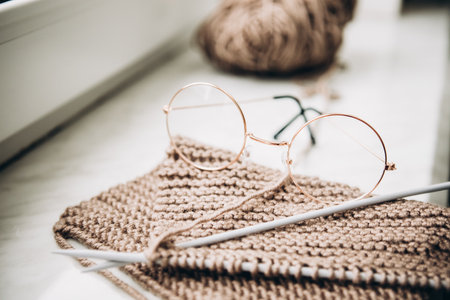Knitting needles with thread and nail polish on a light background. The concept of hobbies, creativity, needlework, handwork. Soft focus, defocusの写真素材