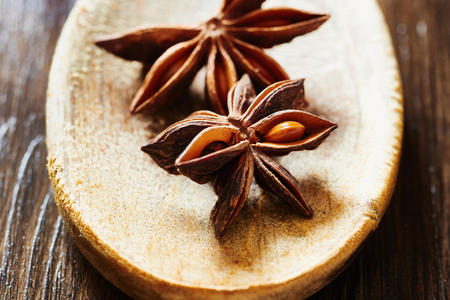 Star anise on wooden spoon on wooden tableの写真素材