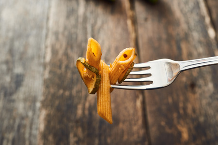 Wholemeal pasta with zucchini taken with forkの写真素材