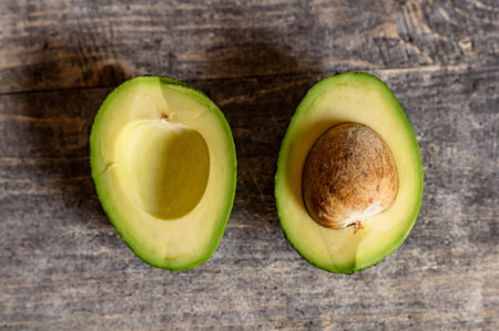 A lovely juicy avocado cut in half with a large pit.の写真素材