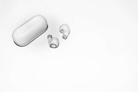 Wireless headphones connected to a phone or smartphone via the network. Small wireless music portable acoustics, white headphones.の写真素材