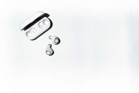 Wireless headphones connected to a phone or smartphone via the network. Small wireless music portable acoustics, white headphones.の写真素材