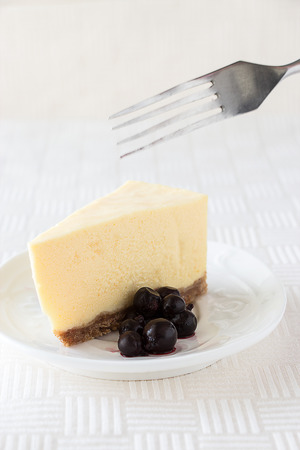 Slice of classic cheesecake on white texture background. Selective focus. Copy spaceの写真素材