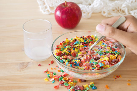 Kids healthy quick breakfast. Colorful rice cereal with milk and apple for kids on wooden...