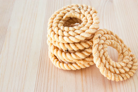 Chakli or Murukku popular vegetarian snack South India. Spiral shaped crisp deep-fried snack. Wooden...