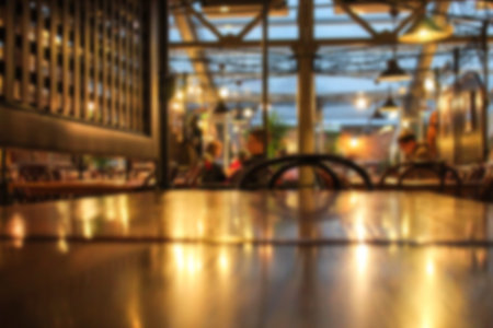 Blurred cafe interior with some people on a background. Coffee house blur background. Evening time
