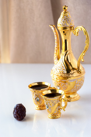 Still life with traditional golden arabic coffee set with dallah and cup. White background. Ramadan concept.の写真素材