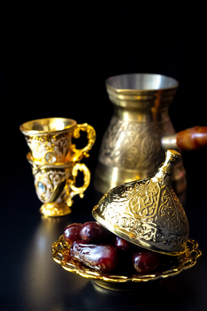 Organic dried dates in traditional arabic golden plate, two cup and jezva. Holy month Ramadan concept. Top viewの写真素材
