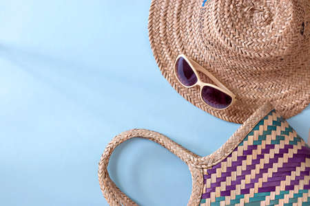Summer straw hat beach, sunglasses and shorts on light blue background. Copy space. Top view.の写真素材