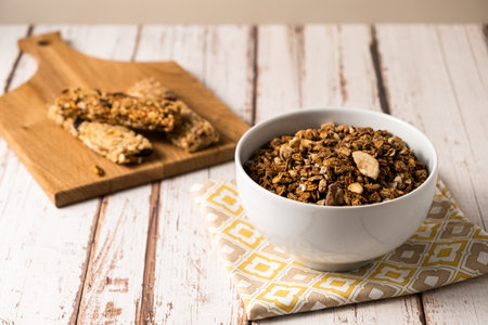 energy fitness breakfast. Chocolate granola with dried fruits, various granola bars on a wooden background.の写真素材