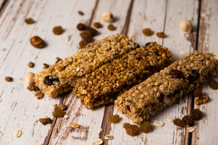 energy fitness breakfast. Chocolate granola with dried fruits, various granola bars on a wooden background.の写真素材