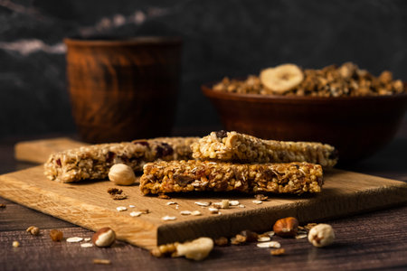 energy fitness breakfast. Chocolate granola with dried fruits, various granola bars on a wooden background.の写真素材
