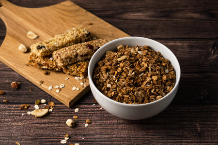 energy fitness breakfast. Chocolate granola with dried fruits, various granola bars on a wooden background.の写真素材
