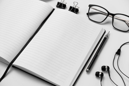 Notebook, pen, glasses and headphones on a white background.の写真素材