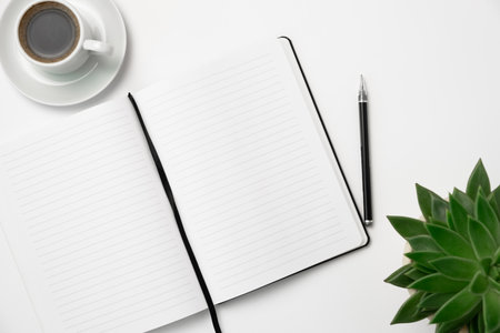 White office desk table with coffee cup, notebook and plant. top view with copy spaceの写真素材