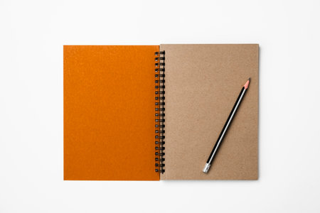 Notebook and pencil on white background. top view. flat layの写真素材