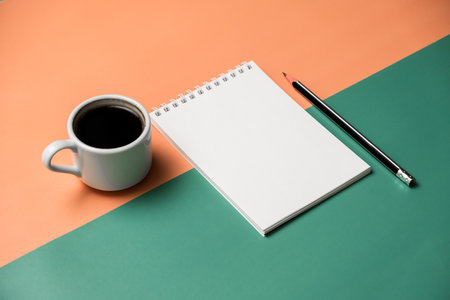 Blank notepad with pen and coffee cup on colorful background.の写真素材