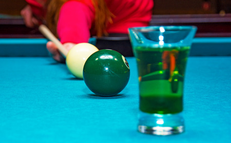 girl playing pool, has the ball and is reflected in the glass. billiard Clubの写真素材